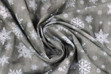 Swirled swatch of snowflake printed fabric in grey (grey marbled look fabric with white tossed snowflakes in various sizes and styles)