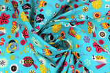 Swirled swatch aqua fabric (aqua/light blue green coloured fabric with tossed brightly coloured drawn birds and flowers allover in various styles sizes in the colourway: yellow, red, orange, mint, black)
