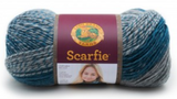 A ball of Lion Brand Scarfie on white background in shade teal silver (medium blue/green and light grey solid and marled colourway)