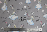 Flat swatch Alice in Wonderland fabric (grey fabric with tossed illustrative Alice in Wonderland character and emblems and text)