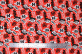Flat swatch rebel riot fabric (bright red fabric with tossed cartoon Cruella heads and tossed assorted black and white text allover "Bad Vibes Only" "Broken Hearted" etc.)
