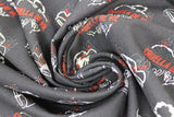 Swirled swatch total chaos fabric (black fabric with repeated outline graphics, white car outline with red lights and black flames around, white Cruella outline with red character name text)