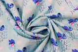 Swirled swatch Ohana fabric (light blue fabric with repeated "Ohana" text design with definition and posing stitch character beside)