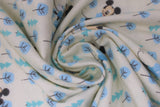 Swirled swatch Mickey in the Meadow fabric (white fabric with small drawing style blue trees and 2 styles with Mickey Mouse characters in blue in various poses)