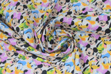 Swirled swatch mickey mouse here comes the fun fabric (white fabric with rows of tight collaged character heads: mickey, minnie, goofy, donald, daffy, pluto)