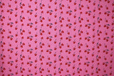 Flat swatch MM Cherry Sweet fabric (bubblegum pink fabric with tossed black stem cherries with red mickey mouse shaped fruit tossed allover)