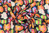 Swirled swatch licensed Muppets printed fabric in Muppets Cast (main heads on black: kermit, piggy, gonzo, fozzie, animal)