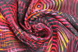 Swirled swatch red/pink fabric (black fabric with large groups of concentric circles in shades of red, pink, yellow and orange allover)