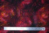 Flat swatch red/pink fabric (black fabric with large groups of concentric circles in shades of red, pink, yellow and orange allover)