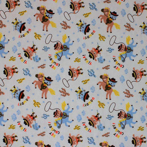 Square swatch Howdy fabric (off white fabric with tossed cartoon cat and dog cowboys on blue horses and hobby horses with tossed cacti in yellow, blue and brown shades and lassos, "Hey Cowboy!" text)