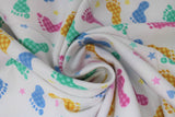 Swirled swatch footsteps fabric (white fabric with tossed footprints in blue, green, yellow and pink with gingham pattern, tossed hearts and stars in same colourway no gingham print)