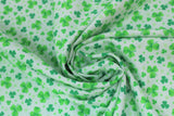 Swirled swatch St. Patrick's Day themed fabric in assorted green shamrocks on green