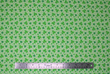 Flat swatch St. Patrick's Day themed fabric in assorted green shamrocks on green