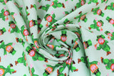 Swirled swatch St. Patrick's Day themed fabric in cartoon leprechauns on light green