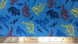 Flat swatch cretaceous dinosaurs printed fabric in blue (bright medium blue fabric with tossed assorted dinosaurs from the cretaceous period in yellow, red, black, blue colours and tossed small mountains/volcanos)
