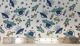 Flat swatch cartoon UFO and aliens printed fabric in white (white fabric with tossed blue cartoon aliens in small teal UFOs with tossed yellow and blue UFOs, teal rocketships, and tossed stars in various colours)