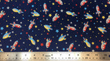 Flat swatch cartoon rocketships and stars fabric in navy (navy fabric with small tossed rocketships, stars, and dots all in grey, red, yellow, blue)