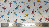 Flat swatch cartoon rocketships and stars fabric in red (white fabric with small tossed rocketships, stars, and dots all in grey, red, yellow, blue)