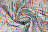 Swirled swatch Yass fabric (teal blue fabric with diagonal repeated "Yass!" text in white letting with rainbow dash horse running through)
