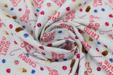 Swirled swatch Candy Land fabric (white fabric with tossed "Candy Land" text in candy cane letters, tossed treats candy canes, fudgesicles, vanilla ice cream cones, candies in blue, pink, red)