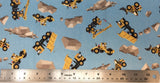 Flat swatch cartoon construction vehicles printed fabric in blue (light blue fabric with tossed yellow construction vehicles: diggers, trucks, etc. and grey rocks tossed)