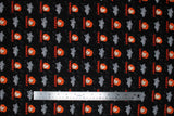 Flat swatch Batteries Included fabric (black fabric with chucky heads and text allover)