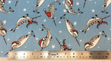 Flat swatch santa hat cartoon narwhals printed fabric in blue (pale medium blue fabric with tossed cartoon grey narwhals with red santa hats and candy cane look tusk and tossed white stars) 