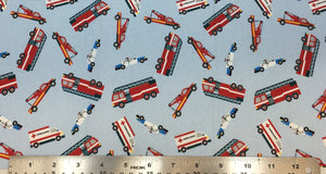 Swatch of cartoon emergency vehicle printed fabric in blue (pale light blue fabric with tossed cartoon police cars, firetrucks and ambulances)