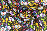 Swirled swatch Sugar Skull Stripe fabric (black fabric with colourful swirly greenery look decor allover in lines of colour: pink, blue, purple, yellow, orange with brightly coloured sugar skulls inside)