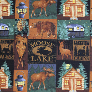 Square swatch Moose Lake themed print (quilt look fabric with square/rectangle badges containing cabin/lake themed photos bears, deer, moose, etc. in dark naturals browns and green colourway with "Moose Lake" and "Lakeview Cabins" text)