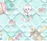 Child-drawn style houses and teddybears with green background printed on quatrefoil-quilted vinyl
