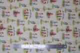 Flat swatch Anne of Green Gables printed fabric (white fabric with repeated characters on grass patches: Anne in grass, Anne on swing, Anne and friend, Teacher, Anne and farm boy, "Anne of Green Gables" text)