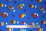 Flat swatch Tossed fabric (medium blue fabric with tossed full colour character trains and black directional arrows, etc.)