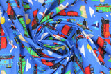 Swirled swatch Blue fabric (medium blue fabric with scattered train related emblems: red, green and blue trains, clouds, houses, mountains, windmills, etc.)