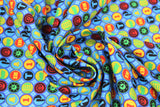 Swirled swatch Symbols fabric (light blue fabric with stripes of circular badges allover with train related symbols within in bright colours)