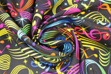 Swirled swatch music notes fabric (black fabric with tossed music notes, clefs, and swoopy staff lines in rainbow colours)