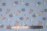 Flat swatch dreamy sheep fabric (pale blue fabric with small tossed cartoon sheep with closed eyes in brown, grey, and white)