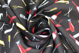 Swirled swatch Tossed Hair Tools fabric (black fabric with tossed drawn style hair tools in full colour: silver scissors, silver straighteners, silver round brushes, red brushes, red blow dryers, gold spray bottles, gold combs, gold scissors, etc.)
