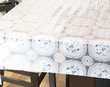 Square photo clear vinyl tablecloth draped over table (white doily look)
