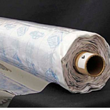 A partly unfurled roll of clear soft vinyl with white backing paper covered in blue motifs.  The end of the roll has a label with a 4 on it.