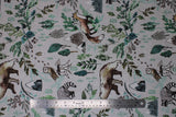 Flat swatch taupe woodland fabric (pale taupe fabric with tossed coloured woodland emblems in drawn style: leaves and greenery, barn owls on stumps, racoons, bears, mountains, etc.)