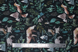 Flat swatch navy woodland fabric (dark navy fabric with tossed coloured woodland emblems in drawn style: leaves and greenery, barn owls on stumps, racoons, bears, mountains, etc.)
