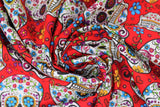 Swirled swatch red fabric (red fabric with medium sized tossed sugar skull heads with colourful decorative floral and swirly designs allover in blue, orange, red, green, purple, etc. with tossed floral)