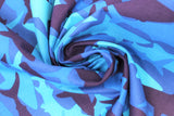 Swirled swatch medium blue fabric with light to dark blue shark silhouettes in camo style design