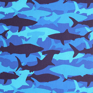 Square swatch medium blue fabric with light to dark blue shark silhouettes in camo style design