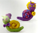 Completed Amigurumi snails (green with yellow shell, purple with multi coloured shell)