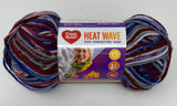 Ball of Red Heart Heat Wave yarn in shade tourist (grey, blues, burgundy colourway)