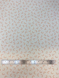 Flat swatch double gauze fabric with small faint rainbows on white