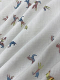 Swirled swatch double gauze fabric with small metallic/rainbow iridescent unicorns on white