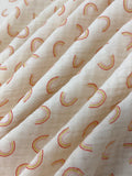 Swirled swatch double gauze fabric with small faint rainbows on white